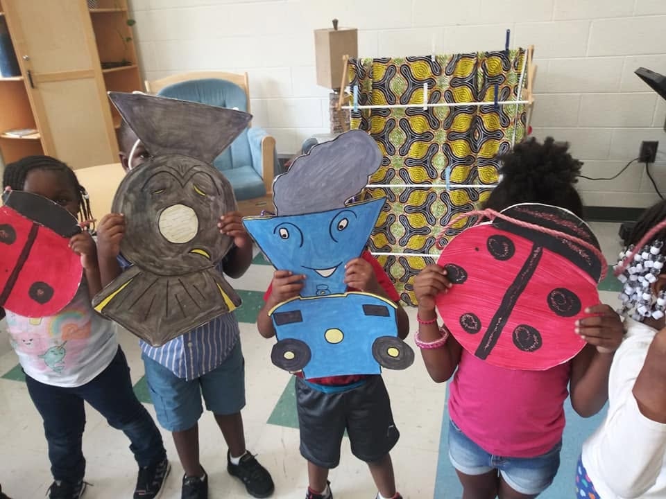 Children holding ladybug and little engine character masks