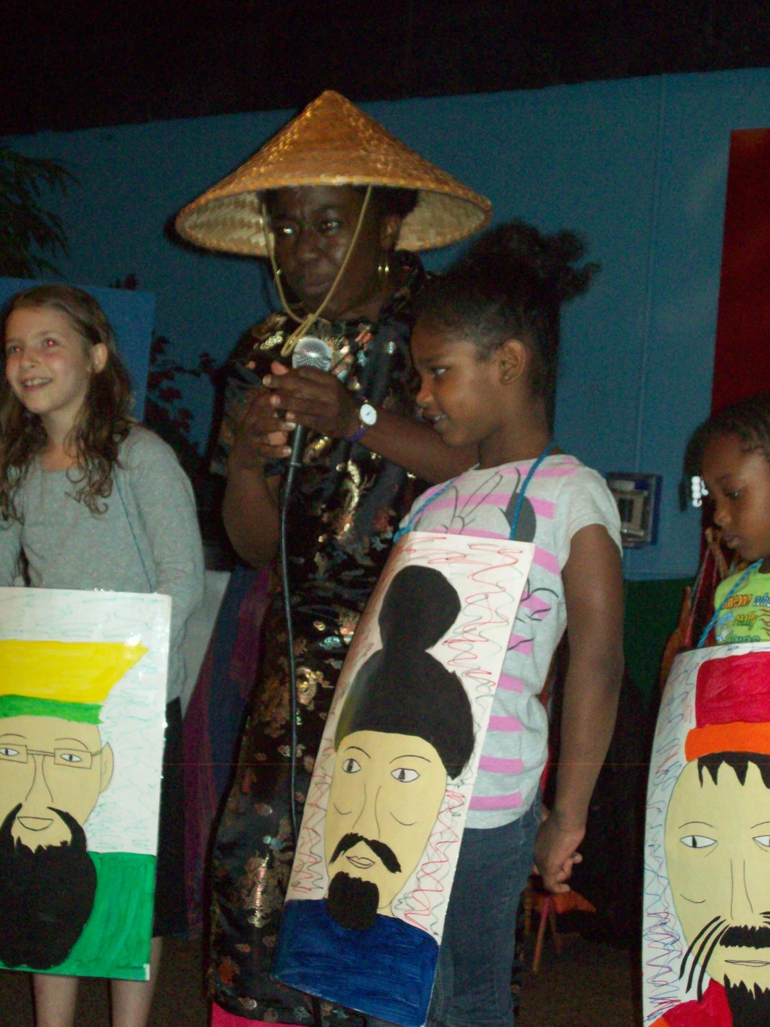 Children displaying cultural artwork with costumes